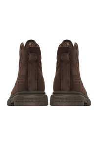 Ruske kožne gležnjače s teksturiranim završetkom, zaobljenim dizajnom, gumene potplate i rupice na stražnjoj strani za lakše oblačenje.