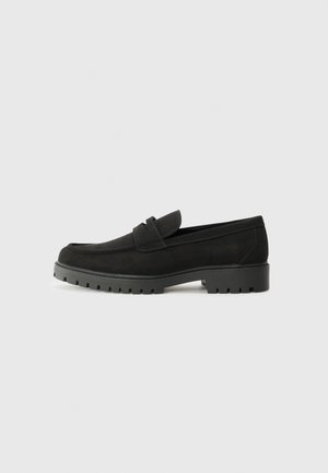 Black suede loafers with a rounded toe, rubber sole featuring tread detailing, and a slip-on design with a front strap.