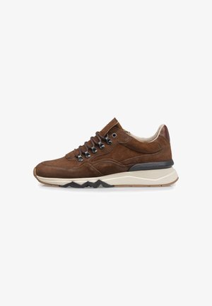 Braune Wildleder-Sneaker mit einer dicken weißen Sohle, schwarzen Akzenten und Metallösen. Sie verfügen über eine runde Zehenpartie und eine strukturierte Oberfläche.