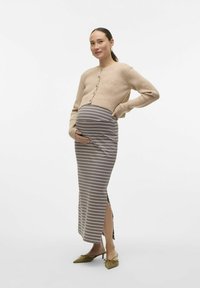 Pletena bež kardigan, siva midi krilna krila z vzdolžnimi črtami in stranskim razporkom, ter zelene pointed flats. Oblačilo je zasnovano za materinstvo.