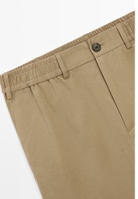 Kaki kalhoty s elastickým pasem, knoflíkovým zapínáním, rovnými předními díly a bočními kapsami. Tkanina má hladkou texturu a matný povrch.