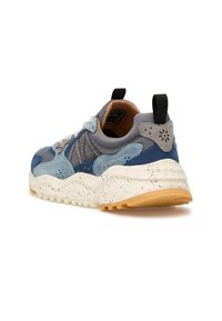 Sneaker chunky in suede blu e grigio con suola bianca maculata e linguetta nera sul tallone, mostrata da un'angolazione laterale posteriore.