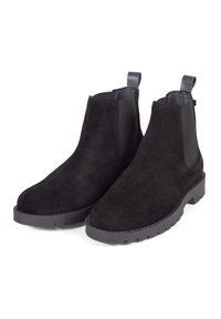 Botas de ante negras hasta el tobillo con paneles laterales elásticos, lazo en el talón y suela de goma texturizada. Presentan una punta redondeada y detalles de costura.