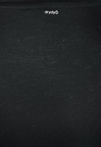 Svart åtsittande topp gjord av ett smidigt, elastiskt tyg. Har en subtilt texturerad yta och en liten logotyp nära halsringningen.