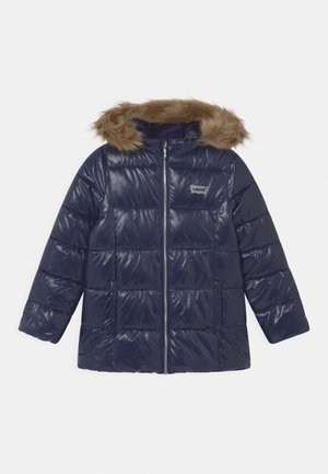 Giacca imbottita blu navy con finitura lucida, cappuccio rifinito in pelliccia, chiusura con zip e design a pannelli cuciti. Presenta due tasche frontali.