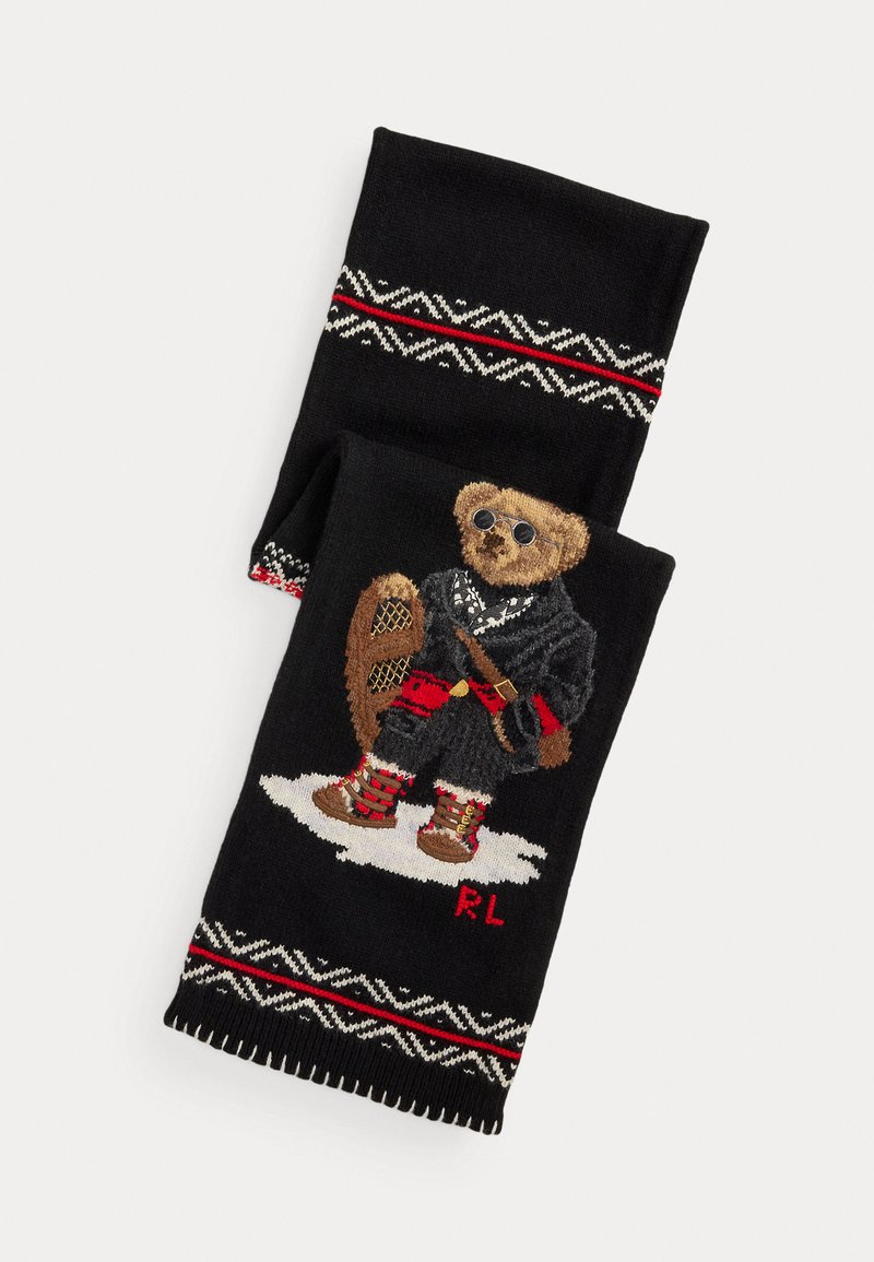 Melnā adīta šalle ar brūna teddy lāča dizainu ziemas tērpā. Malās ir baltas un sarkanas rakstainas akcenti.