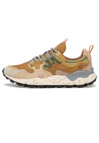 Mlokotrénkové tenisky v několika barvách se směsí tan, olivově zelené a béžové nubukové kůže, s tečkovanou bílou mezipodešví a černou podrážkou. Součástí jsou gumové akcenty.