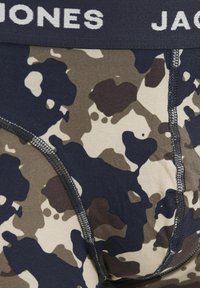 Caleçon pour homme avec un motif camouflage en bleu, marron et beige. Matière en coton doux avec une ceinture élastique contrastante portant l'inscription "JONES".