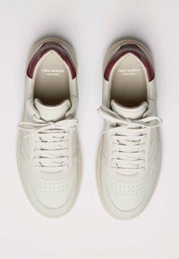 Bílé kožené tenisky s vínovými detaily, kulatou špičkou, perforovanými prvky, plochými tkaničkami a texturovanou podrážkou. Logo vytištěné uvnitř.