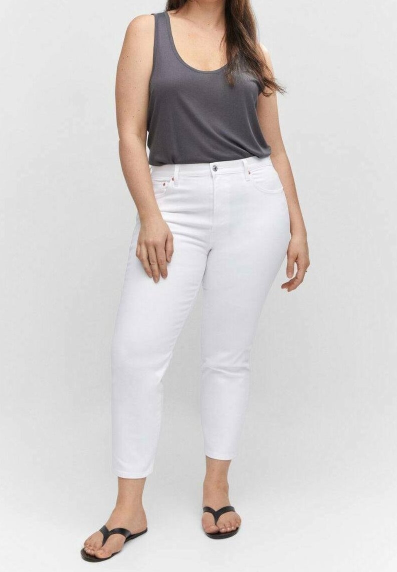 Jeans blancos hasta los tobillos combinados con una camiseta sin mangas gris oscuro y sandalias negras de tipo flip-flop. Tela suave con un diseño ajustado y estilo de cinco bolsillos.