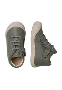 Zelené kožené boty s texturovanou béžovou gumovou podrážkou, šněrováním vpředu a bočním zipem. Zaoblená špička a měkké vnitřní polstrování.