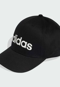 Gorra de béisbol negra hecha de tela, con un logotipo blanco de "adidas" en la parte frontal, visera curva y superficie texturizada.