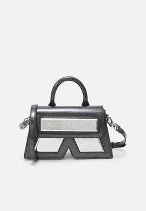 Zwarte glinsterende handtas met bovenhandvat, afneembare schouderriem, zilveren logoplaatje en spiegelend geometrisch paneel aan de voorkant.