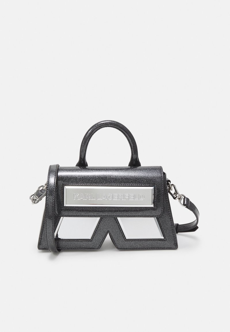 Sac à main noir pailleté avec poignée supérieure, bandoulière amovible, plaque logo argentée et détail de panneau géométrique miroir sur le devant.