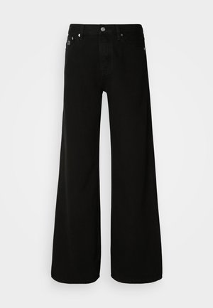 Mustad laiad mustad teksapüksid, mis on valmistatud denimist, kõrge vöökohaga, klassikalise viie tasku kujundusega ning hõbedase nupuga kinnitamine.