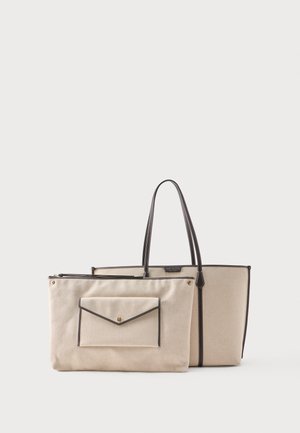 Bež platnena torba s črnim robom in ročaji, skupaj z ujemajočo se snemljivo torbico s sprednjim žepkom v obliki ovojnice in s pritrdilnim zaskočnim zapiranjem.