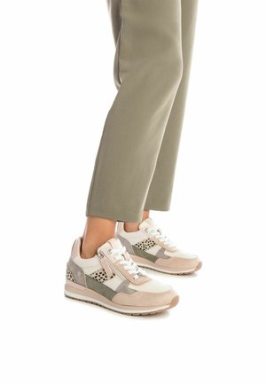 Zapatillas en beige y gris con paneles de ante y malla, que presentan cordones blancos, una suela acolchada y un patrón decorativo de puntos negros.