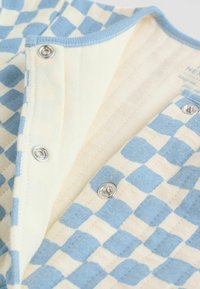 Haină cu mâneci scurte, cu model șah alb-albastru deschis, nasturi capsa argintii și material moale, texturat.