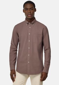 Camicia marrone a maniche lunghe con bottoni, colletto a punta, taschino sul petto e bottoni bianchi, realizzata in un tessuto liscio.