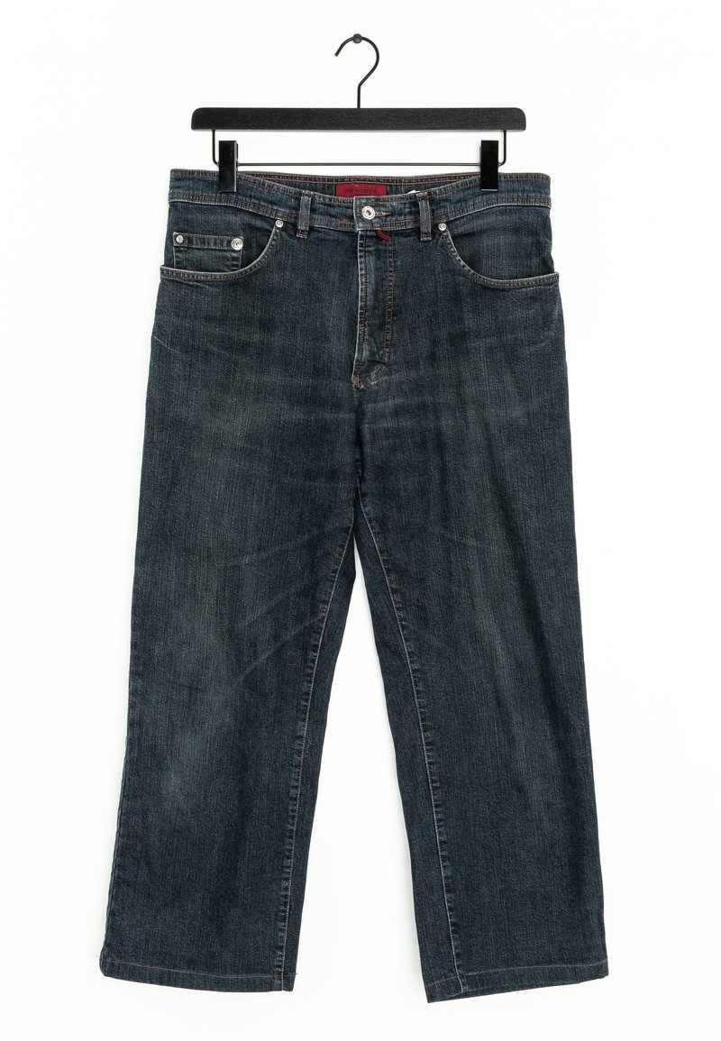 Jeans in denim blu scuro con taglio dritto, cinque tasche, rivetti in rame e un accento rosso sulla vita, appesi a un gancio nero.