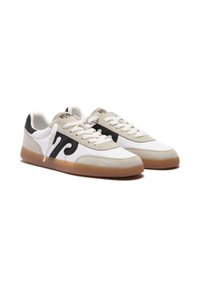 Un paio di sneakers bianche a basso profilo con dettagli in suede beige, design a onda nera sui lati, lacci bianchi e suole in gomma naturale su uno sfondo bianco.