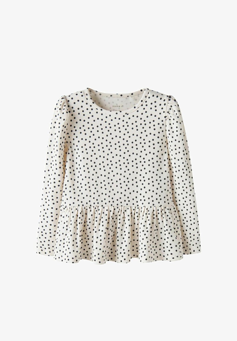 Haut crème à manches longues avec pois noirs, col rond, et un ourlet peplum froncé à la taille.