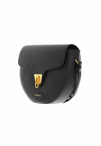 Černá kožená crossbody taška s křivkovým tvarem, zlatým uzávěrem a embosovaným logem na přední straně. Součástí je nastavitelné pouzdro.