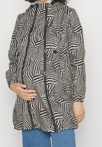 Colori: grigio con strisce zebra nere. Materiale: tessuto leggero. Design: con cappuccio, zip frontale, due tasche. Vestibilità ampia con polsini elastici.