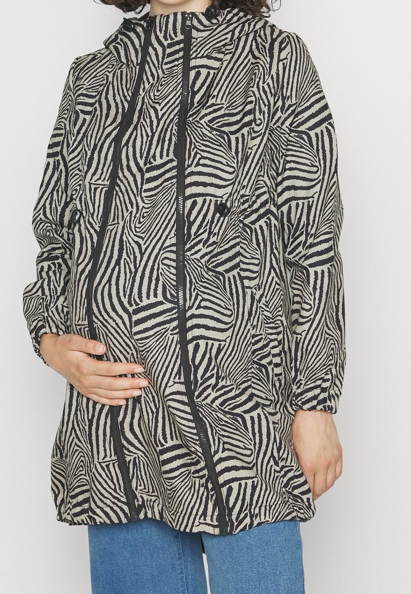 Colori: grigio con strisce zebra nere. Materiale: tessuto leggero. Design: con cappuccio, zip frontale, due tasche. Vestibilità ampia con polsini elastici.