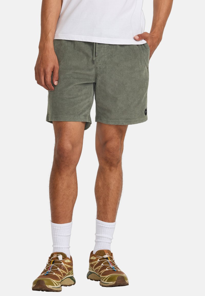 Olijfgroene shorts van zachte stof met een elastische tailleband, voorzien van zijzakken en een klein logo-embleem aan de zoom.