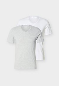 Deux t-shirts à manches courtes avec col en V, un gris clair devant et un blanc derrière, présentés sur un fond clair uni.