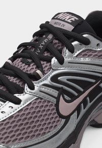 Αθλητικό παπούτσι Nike Moto 2K σε μωβ και ασημί με μαύρα κορδόνια, άνω μέρος από δίχτυ και ροζ λογότυπο Nike swoosh στο πλάι.