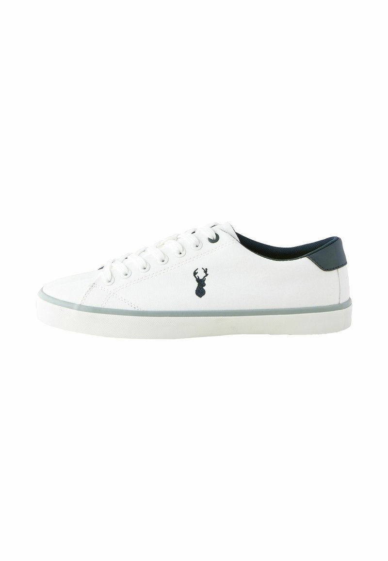 Witte canvas sneaker met een marineblauwe hielaccent en een hertenlogo aan de zijkant. Bevat ronde veters en een rubberen zool.