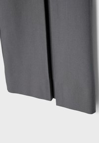 Grijze stoffen gordijn met een verticale centrale spleet, recht hangend tegen een effen witte achtergrond.