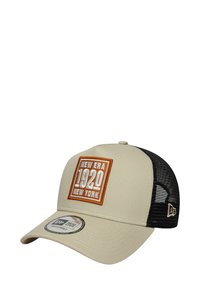Beige Baseballcap mit einem schwarzen Mesh-Rücken, ausgestattet mit einem gestickten quadratischen Patch, der "NEW ERA 1920 NEW YORK" in Orange und Weiß zeigt.