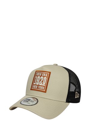 Gorra de béisbol beige con una parte trasera de malla negra, que presenta un parche cuadrado bordado con "NEW ERA 1920 NEW YORK" en naranja y blanco.