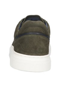 Baskets en daim vert avec une semelle en caoutchouc blanc, présentant une texture lisse et une forme arrondie, des coutures détaillées et une bande d'accent bleu.