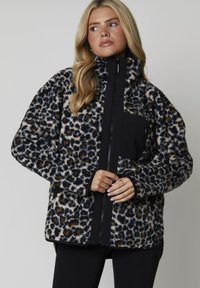 Jakt i leopardmönster med svarta accenter, dragkedjestängning och framficka. Mjukt, strukturerat tyg med avslappnad passform och hög krage.