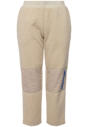 Pantalones beige forrados de felpa con una superficie texturizada, que presentan parches de tela beige en las rodillas y un bolsillo con cremallera azul en el lado derecho.