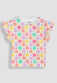 Camiseta de algodón de manga corta con un patrón de ajedrez multicolor que presenta gráficos de frutas y flores. Mangas con volantes en acentos rosas.