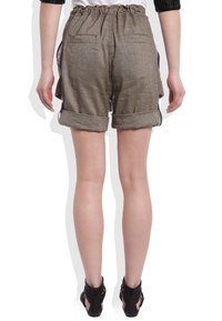 Brązowe lniane szorty z podwiniętymi rękawami, elastycznym pasem, dwiema tylnymi kieszeniami, widocznymi detalami tekstury, noszone z czarnymi sandałami na paski.