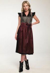 Luipaardprint lijfje met gerimpelde mouwen, maroon satijnen rok, zwarte accenten en een bijpassende strik in de taille; gecombineerd met zwarte enkelboots.