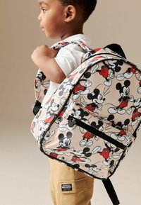 Sac à dos avec une base rose et un motif Mickey Mouse ludique en noir et rouge. Comprend des bretelles réglables et une poche zippée à l'avant.