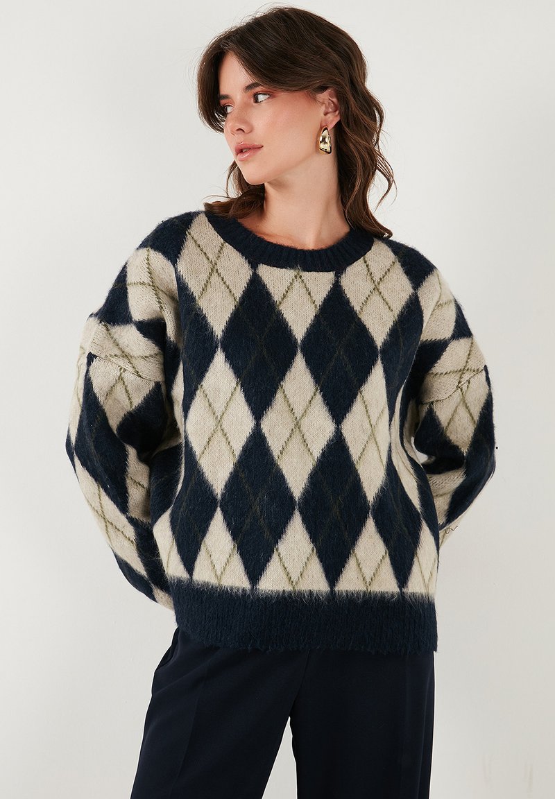 Maglione a rombi nei colori blu navy e crema con una finitura morbida e testurizzata; presenta un collo rotondo e maniche leggermente a sbuffo.