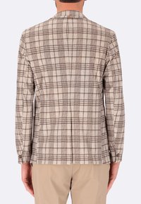 Blazer a quadri beige con motivo a righe marroni, con spacco centrale e polsini con bottone. Tessuto morbido con design strutturato, vestibilità sartoriale.