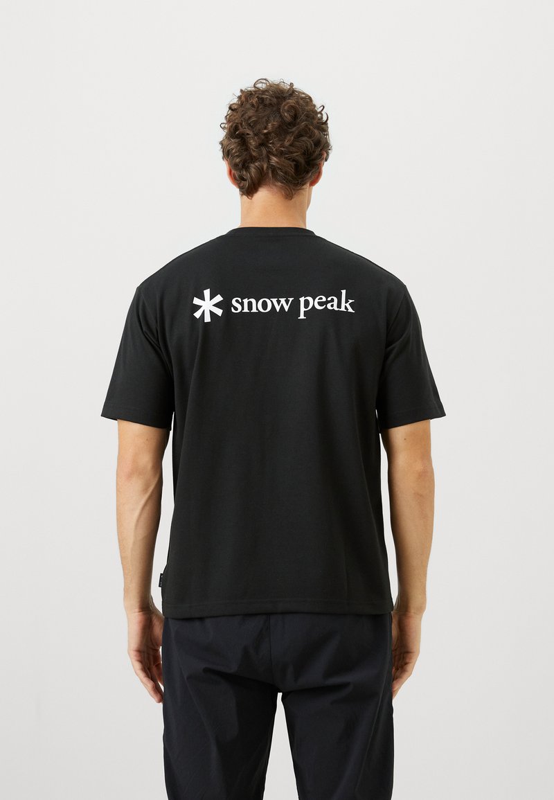 Black cotton t-shirt with short sleeves, crew neck, and a white "snow peak" logo on the back. Smooth texture, relaxed fit.