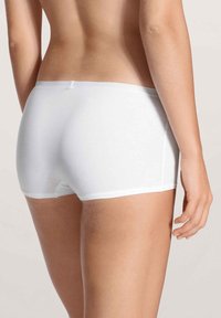 Weiße Baumwoll-Hipster-Shorts mit einer sanften Textur, die einen tiefen Bund und glatte Kanten aufweisen, von hinten betrachtet.