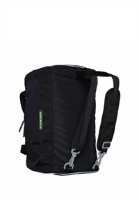 Mochila negra con correas ajustables, hecha de tela texturizada. Cuenta con un logo verde y detalles en hardware gris. Forma rectangular compacta.