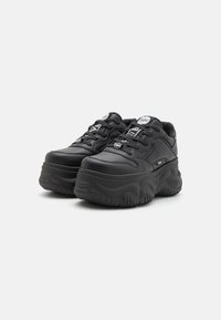 Black platform sneakers with a textured rubber sole, rounded shape, padded collar, and multicolored laces, featuring branded accents.
