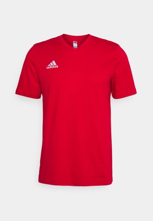Camiseta de algodão vermelha com mangas curtas, design em forma de V e logótipo branco da Adidas no lado esquerdo do peito. Textura suave, sem padrões visíveis.